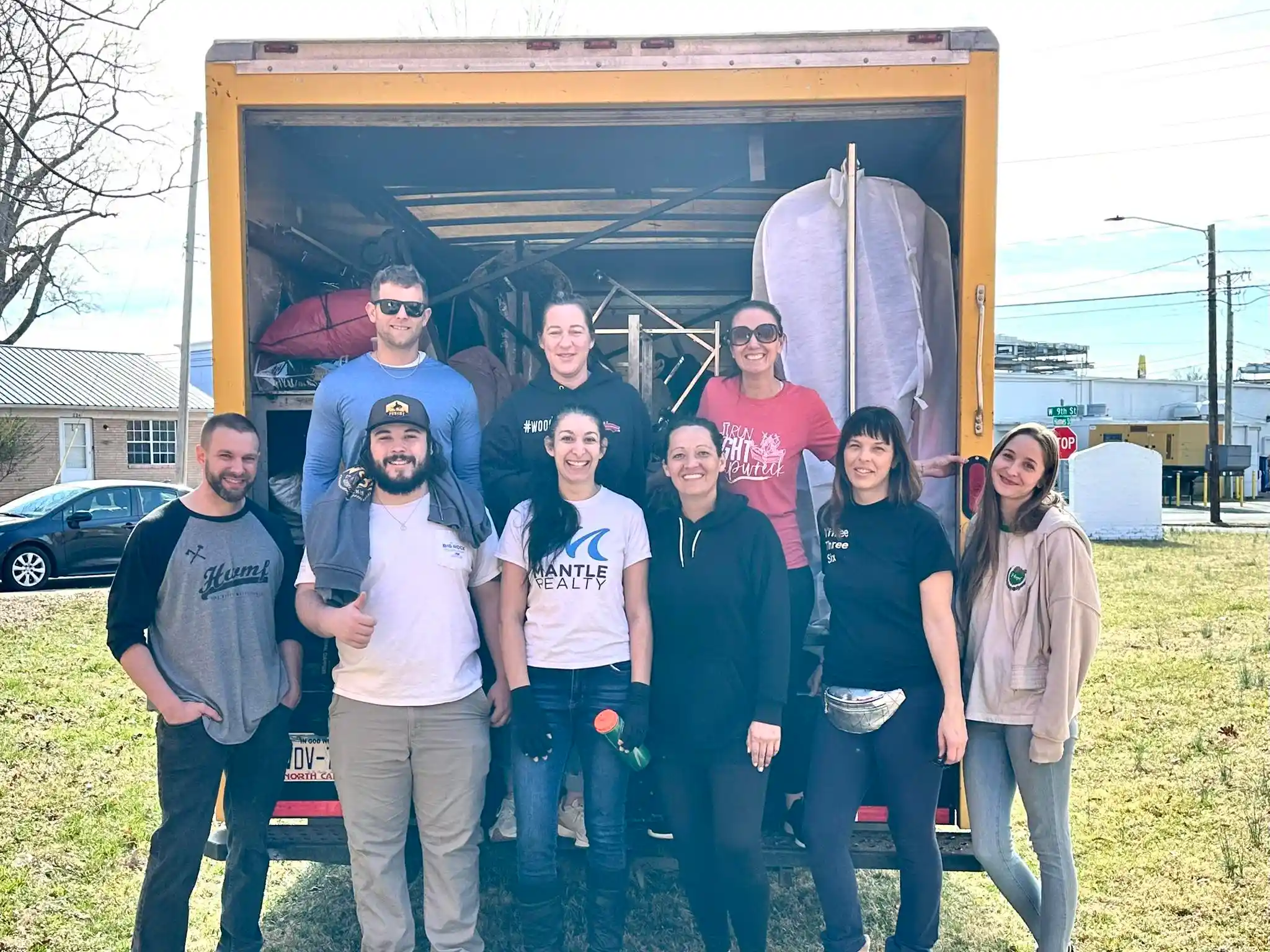 Mantle Realty agents loading prom dresses for Prom Project community event
