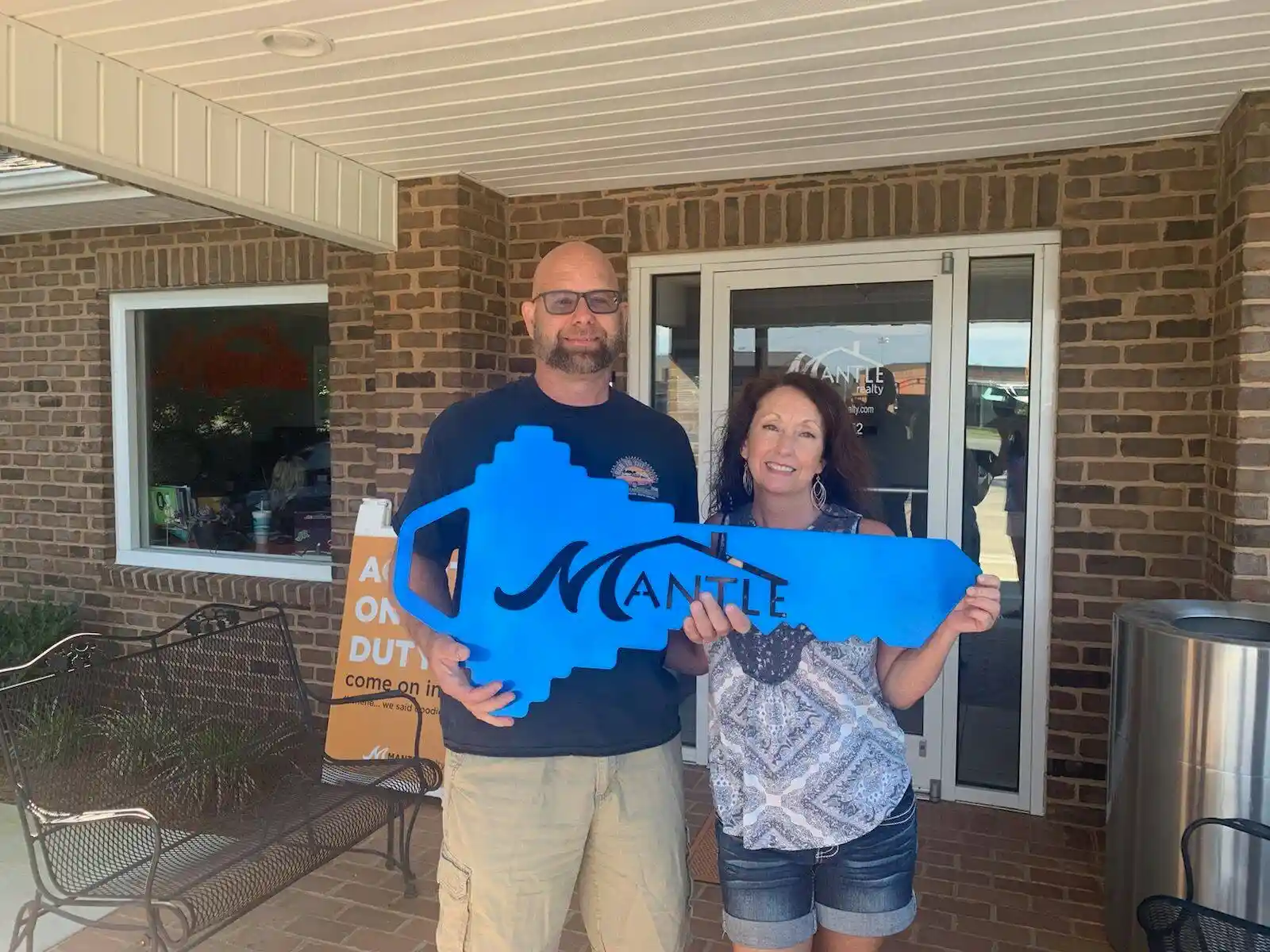 Happy buyer holding the Mantle key after closing