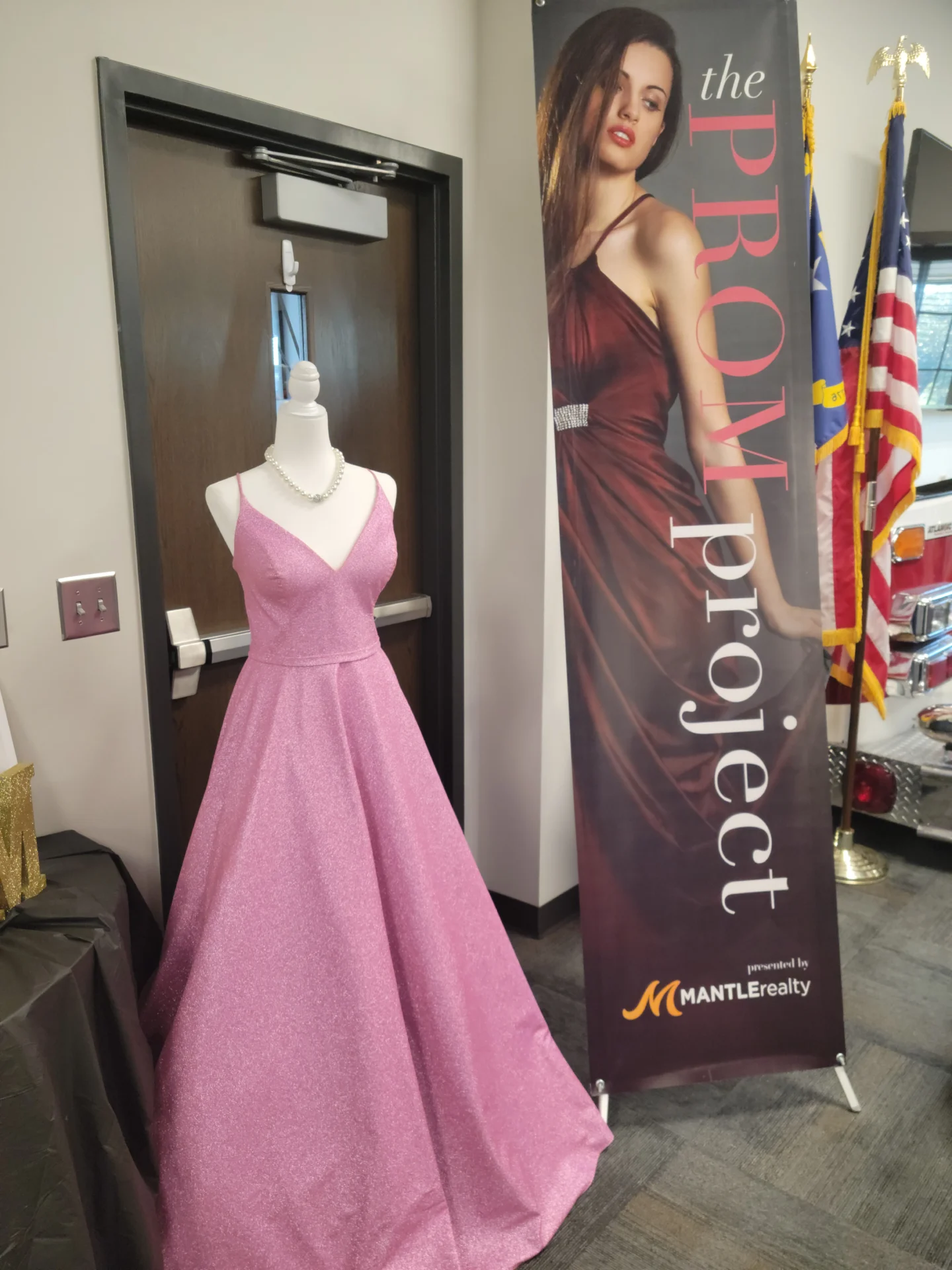 Prom Project sign beside a dress display
