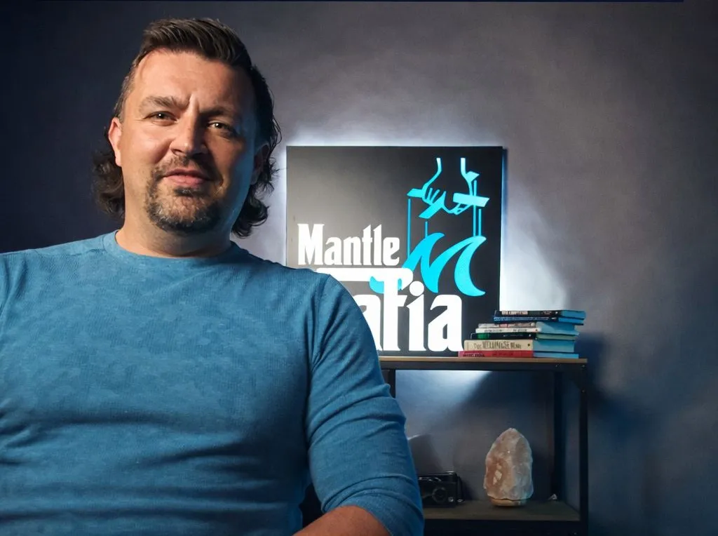 Dustin standing in front of the Mantle Mafia sign at Mantle Realty
